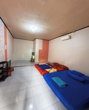 A room with two beds, a television, and a water dispenser.