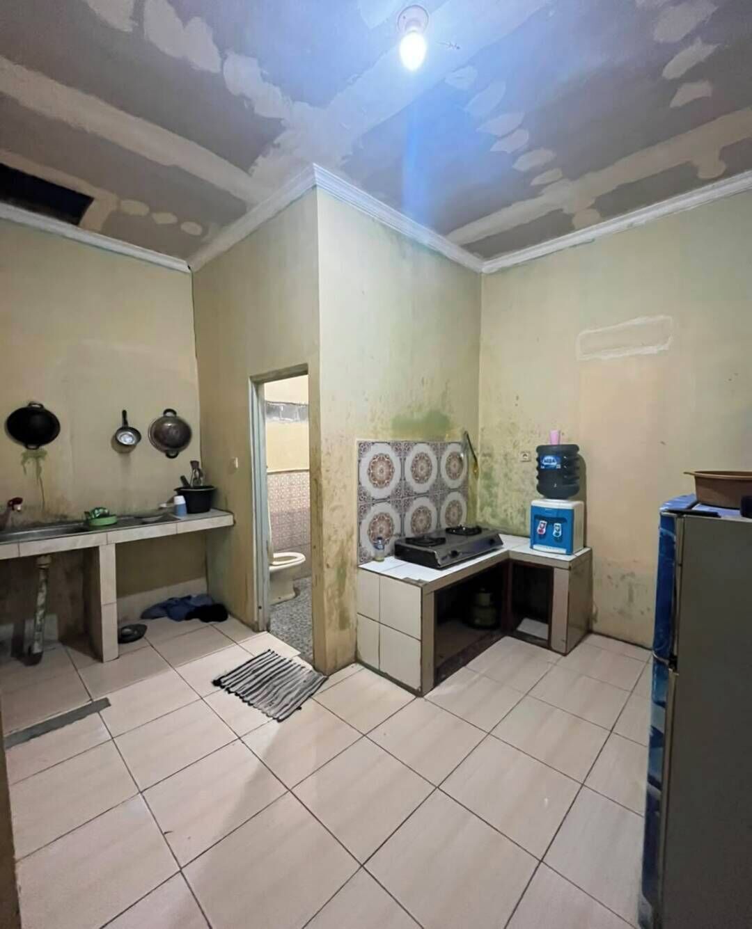 A kitchen with a sink, stove, and water dispenser.