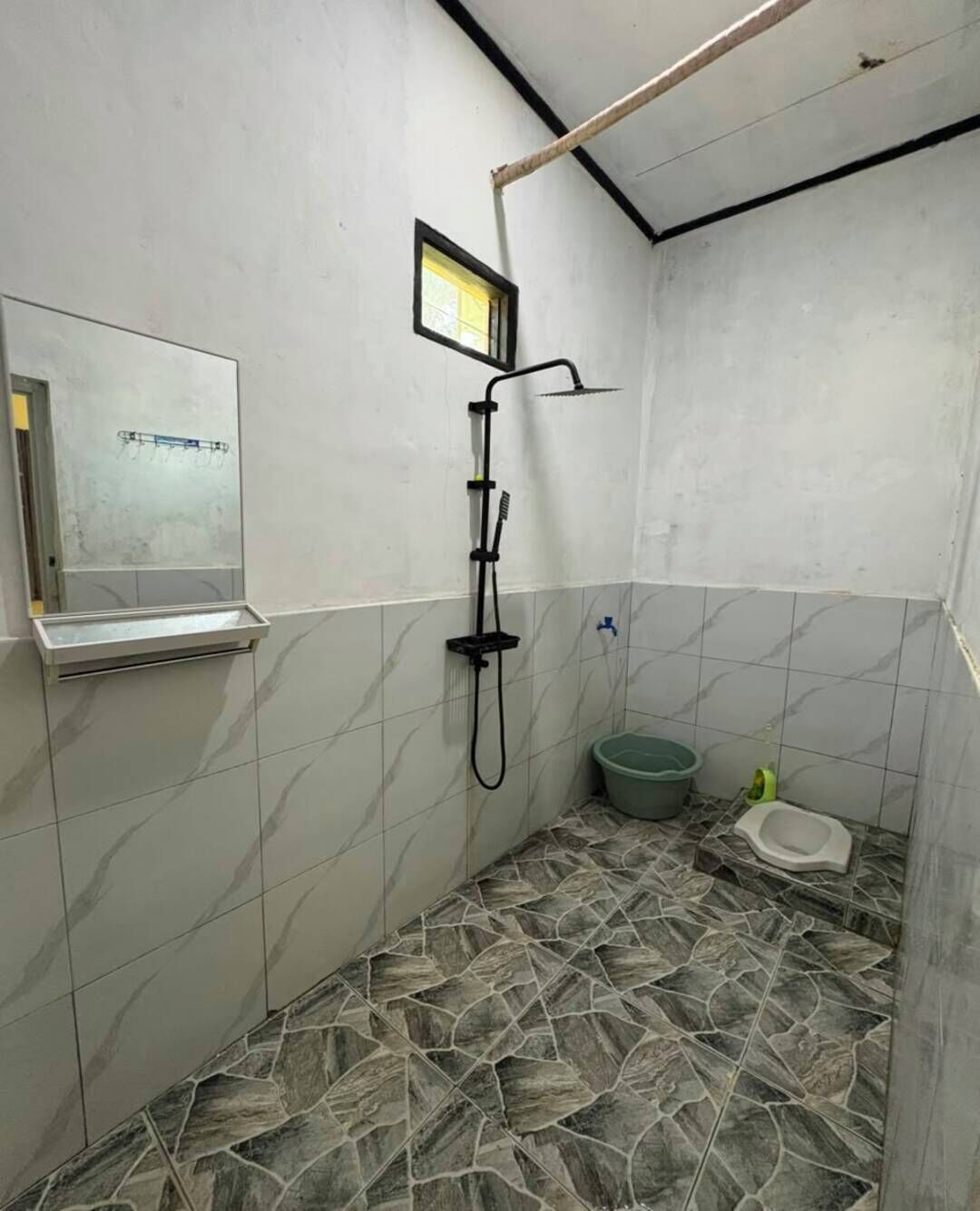A small bathroom with a shower, a toilet, and a sink.