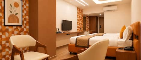 Quarto de hotel com uma cama, mesas de cabeceira, televisão e uma cadeira.