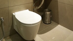 Une salle de bain moderne avec des toilettes, un lavabo et un miroir.
