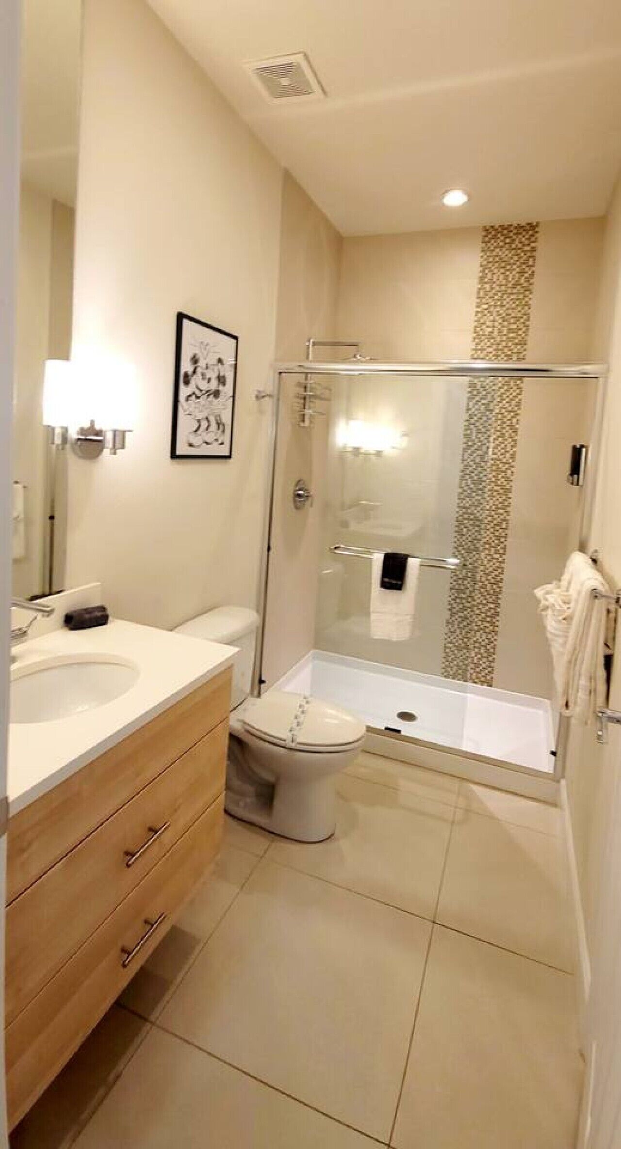 A modern bathroom with a toilet, sink, and shower area.