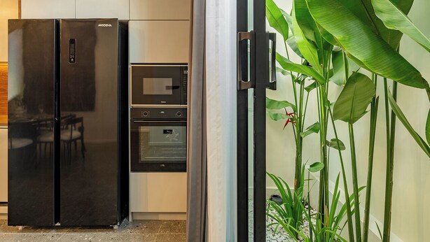 A kitchen with a black refrigerator, a microwave, and an oven. - Chic 2BR Umalas Villa with Workspace (Badung)