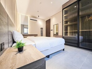 Un dormitorio moderno con cama, mesita de noche y un espejo grande.