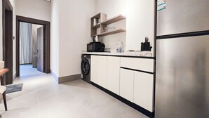 A modern kitchen with a built-in washing machine, a refrigerator, and a countertop with a sink. - MR STAY (Riyadh)