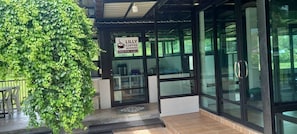 A coffee shop entrance with a sign indicating it is open from 07:00 to 11:00. - Lilly Home (Khaem Son)