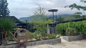 A courtyard with a sign, a solar-powered lamp, and a view of mountains. - Lilly Home (Khaem Son)
