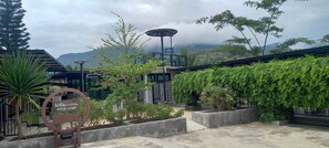 Un patio con un letrero, una lámpara solar y vistas a las montañas.