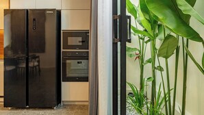 A kitchen with a black refrigerator, a microwave, and an oven. - Peaceful 2BR Umalas Villa Near Seminyak (Badung)
