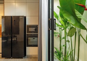 Eine Küche mit einem schwarzen Kühlschrank, einer Mikrowelle und einem Backofen.