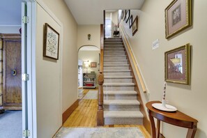 A staircase with a wooden handrail and carpeted steps leading to a landing. - Walk to Main St Stroudsburg! Historic Dtwn Home (Stroudsburg)