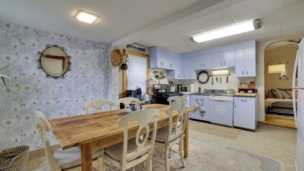 A cozy kitchen with a dining table, chairs, and a variety of kitchen appliances. - Walk to Main St Stroudsburg! Historic Dtwn Home (Stroudsburg)