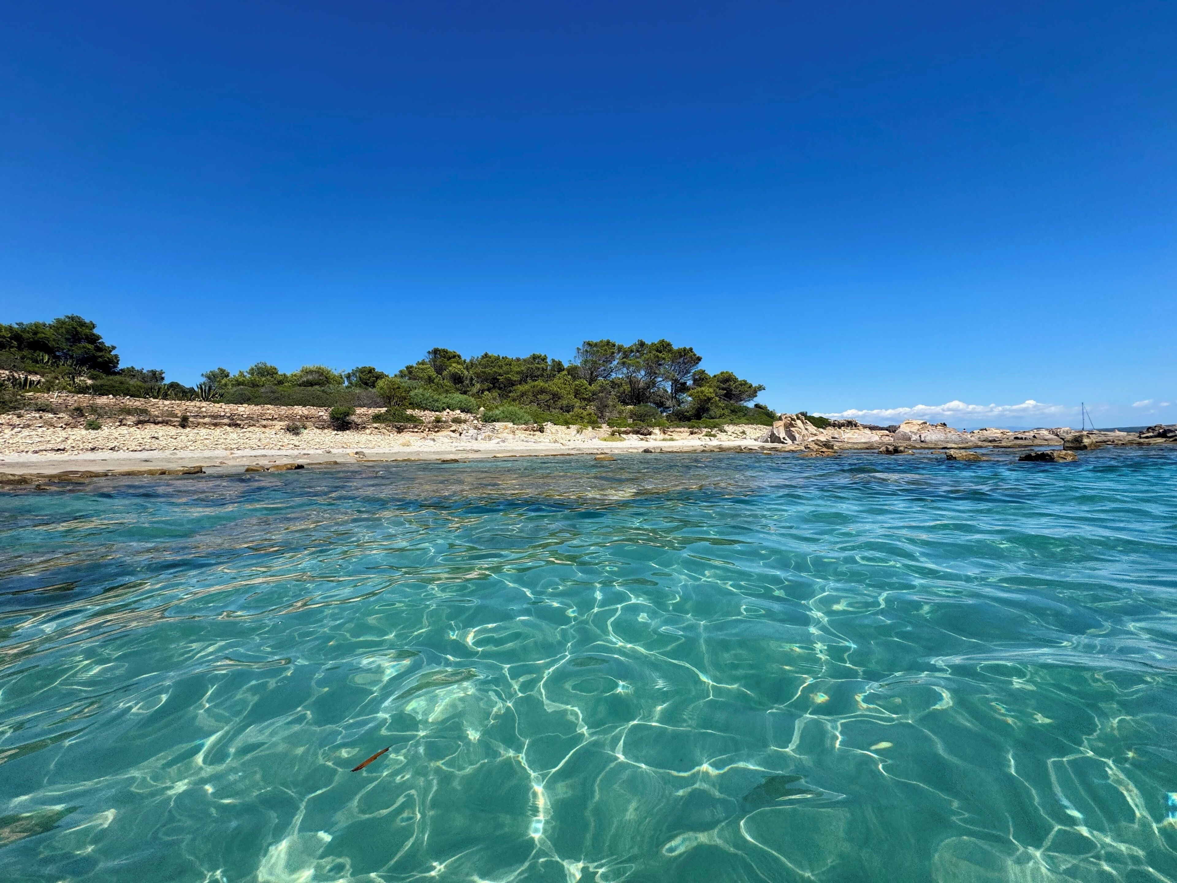 Freie Weitsicht auf die Küste mit Sandstrand und Felsen.