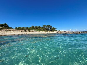 En vacker utsikt över kusten med en sandstrand och klippiga utskjutande partier.