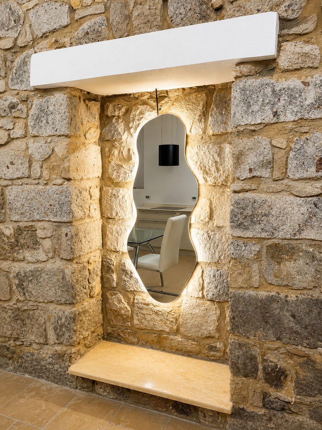 A stone wall with a built-in bench and a mirror.