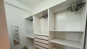A walk-in closet with open shelves, a mirror, and hanging space. - Maison Tabarka: Comfort and Design Suites in the Historic Center of Carloforte (Carloforte)