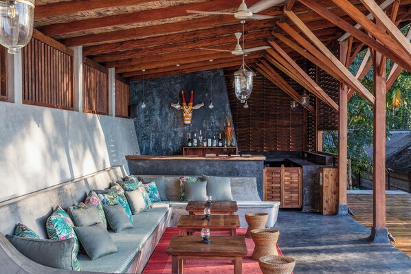 An outdoor seating area with a bar and a stone wall.