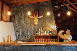 A bar area with a wooden counter, a decorative animal head, and bottles of liquor. - Jalakara Havelock (Port Blair)