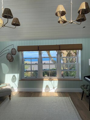A room with a large window, a woven ceiling light fixture, and a view of the outdoors. - New Stunning house St Ives with parking (Saint Ives)