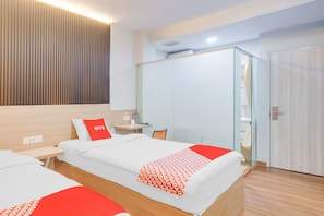 A hotel room with two beds, a bedside table, a chair, a wardrobe, and a mirror. - Luxury Deluxe DBL Retreat W/ Free WiFi and Parking (Jakarta)