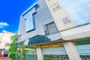 A modern hotel with a reflective glass facade, large windows, and a visible entrance. - Luxury Deluxe DBL Retreat W/ Free WiFi and Parking (Jakarta)