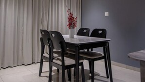 A modern dining area with a table and chairs, a ceiling fan, and a decorative light fixture. - Shourya Resort and lawn Panhala (Panhala)
