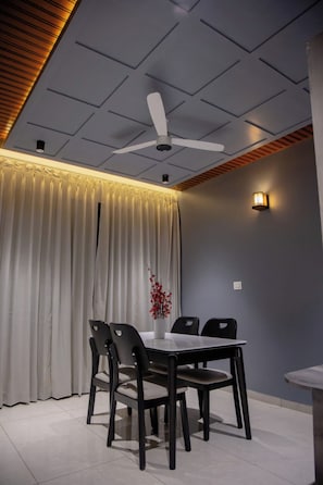 A modern dining area with a table and chairs, a ceiling fan, and a decorative light fixture.