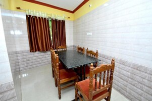Un comedor con una mesa rectangular rodeada de sillas de madera con asientos acolchados.