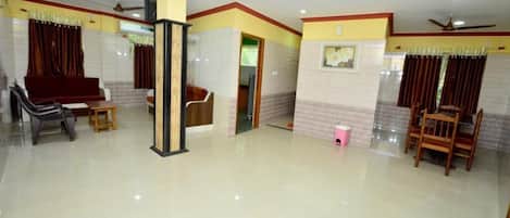 A spacious room with a high ceiling, a ceiling fan, and a polished floor.