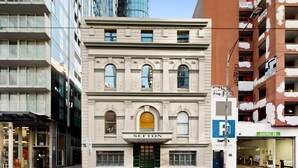 A historic building with a classic facade, a prominent entrance, and a parking sign indicating a parking facility nearby. - Spacious 3-Bed Apartment in Melbourne CBD (Melbourne)