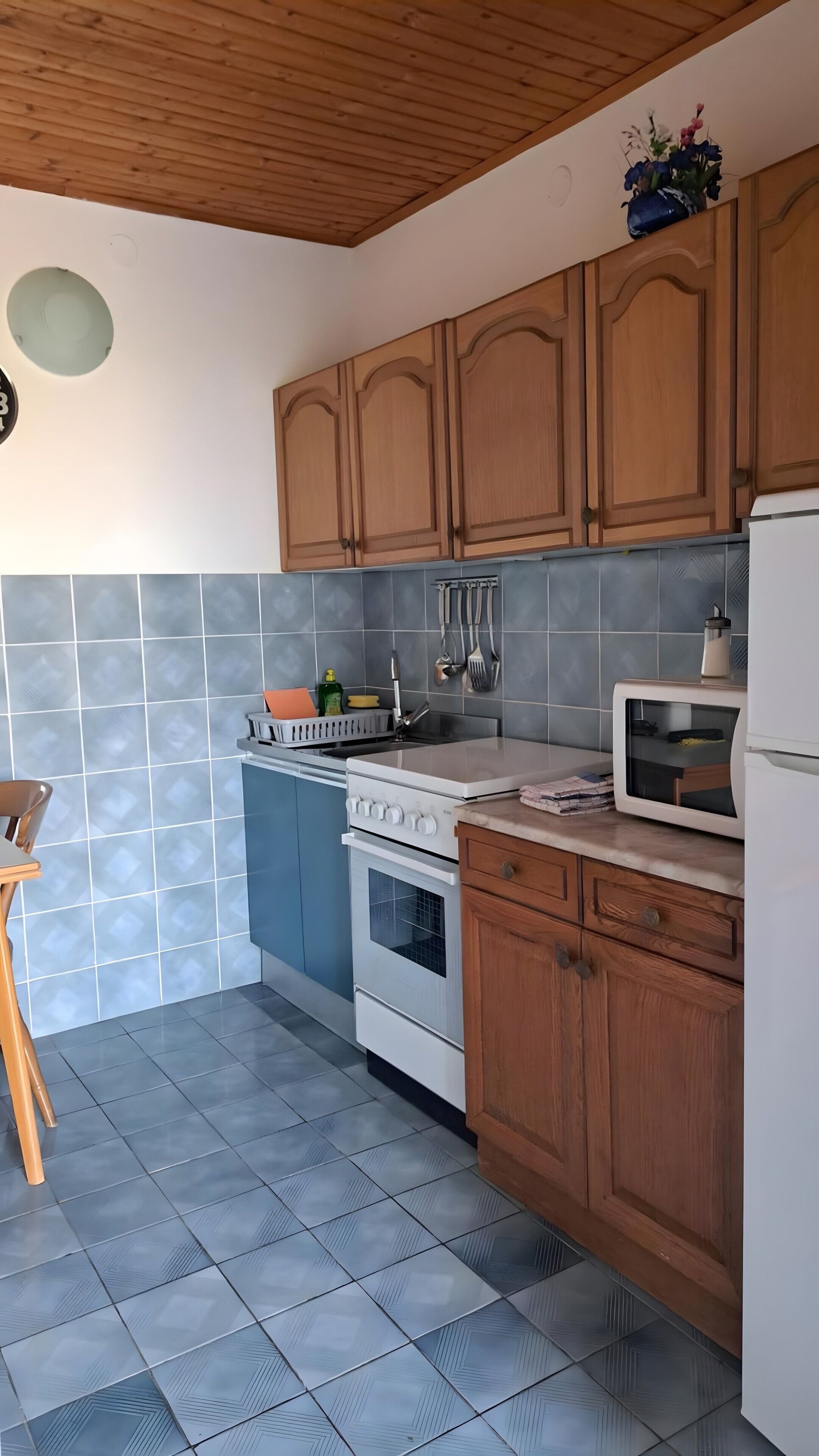Een koelkast, een magnetron, een oven, kookgerei, borden en bestek