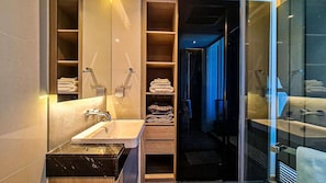 Een moderne badkamer met een wastafel, spiegel en planken voor handdoeken.