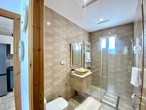 A modern bathroom with a glass shower enclosure, a vanity with a round sink, and a toilet. - Charming 3-Bedroom Apartment in Historic Carthage, Tunisia (Site archéologique de Carthage)