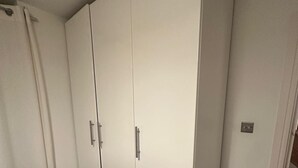 A bedroom with a bed, a wardrobe, and a door leading to another room. - Charming 1-Bedroom Apartment in Central London (London)