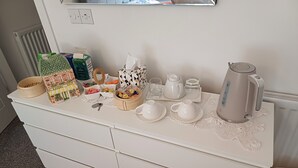 A white dresser with a tea set, a kettle, and various containers. - Holiday home with private bathroom (Edinburgh)