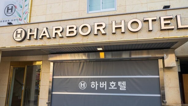 The exterior of Harbor Hotel with a prominent sign and a closed entrance. - Hotel Harbor (Tongyeong)