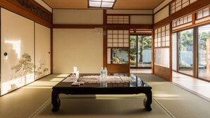 A traditional Japanese room with tatami flooring, a low table, and sliding doors.