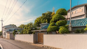 A residential street with houses, a gated entrance, and a clear sky.