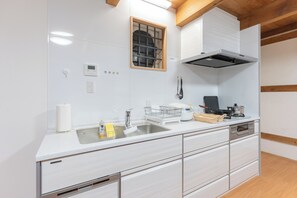 A modern kitchen with a stainless steel sink, a built-in oven, and a range hood.