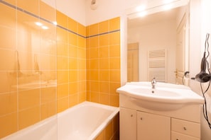 Ein Badezimmer mit einer weißen Badewanne, einem weißen Waschbecken und einem Spiegel darüber.