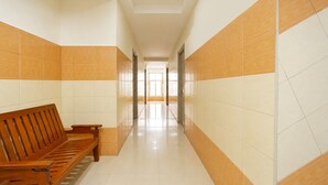 A hallway with a wooden bench, tiled walls, and a bright interior.