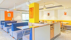 A modern restaurant interior with booths and tables, a bright color scheme, and artwork on the walls. - Super Collection O Pune Nagar Road Viman (Pune)