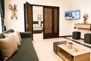 Ein modernes Wohnzimmer mit einer Couch, einem Couchtisch und einem Fernseher.