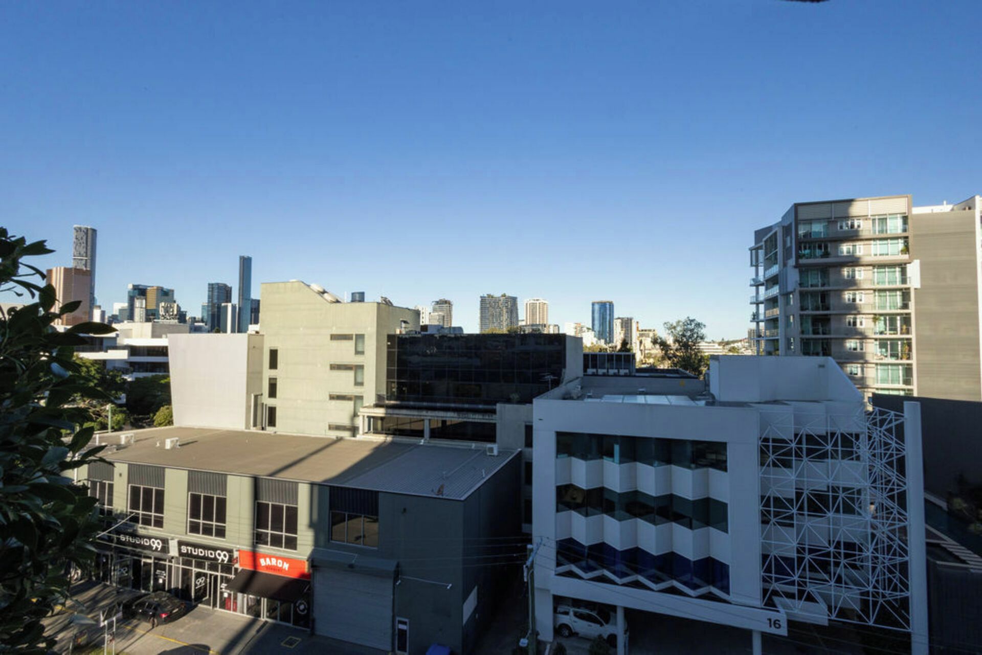 A cityscape with modern buildings, including a multi-story structure with a unique geometric facade.