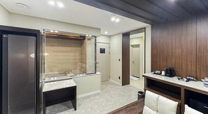 Une chambre d’hôtel avec un dressing, un petit bureau avec une chaise et une machine à café.