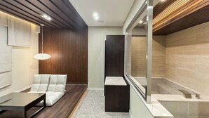 A modern interior with a seating area, a dark accent wall, and a glass partition. - HotelArena514 (Seoul)