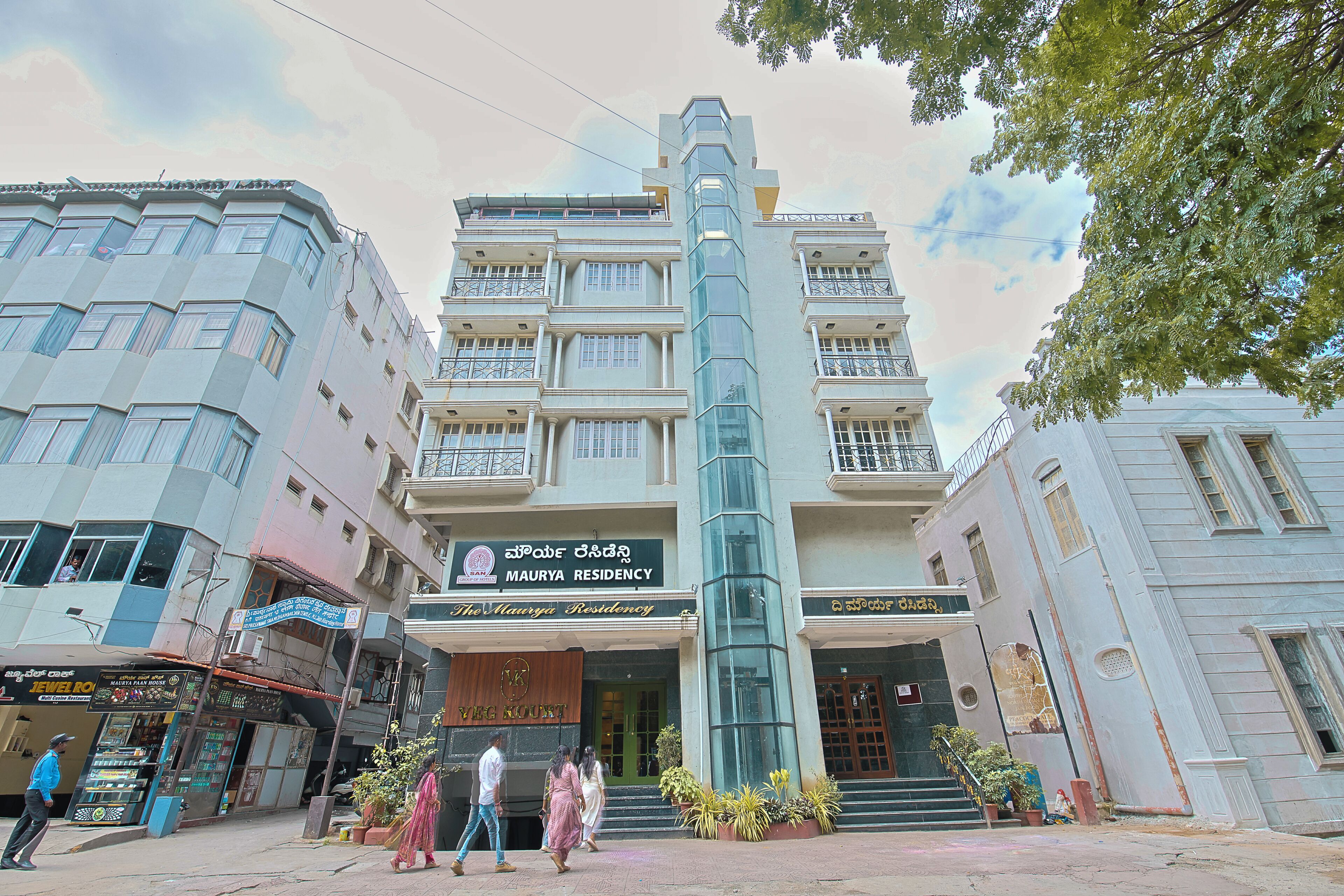 A multi-story building with a sign for 'MAURYYA RESIDENCY' and a staircase leading to the entrance.