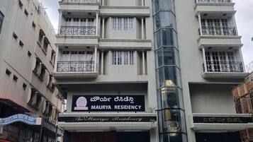 A multi-story building with a sign for Maurya Residency.