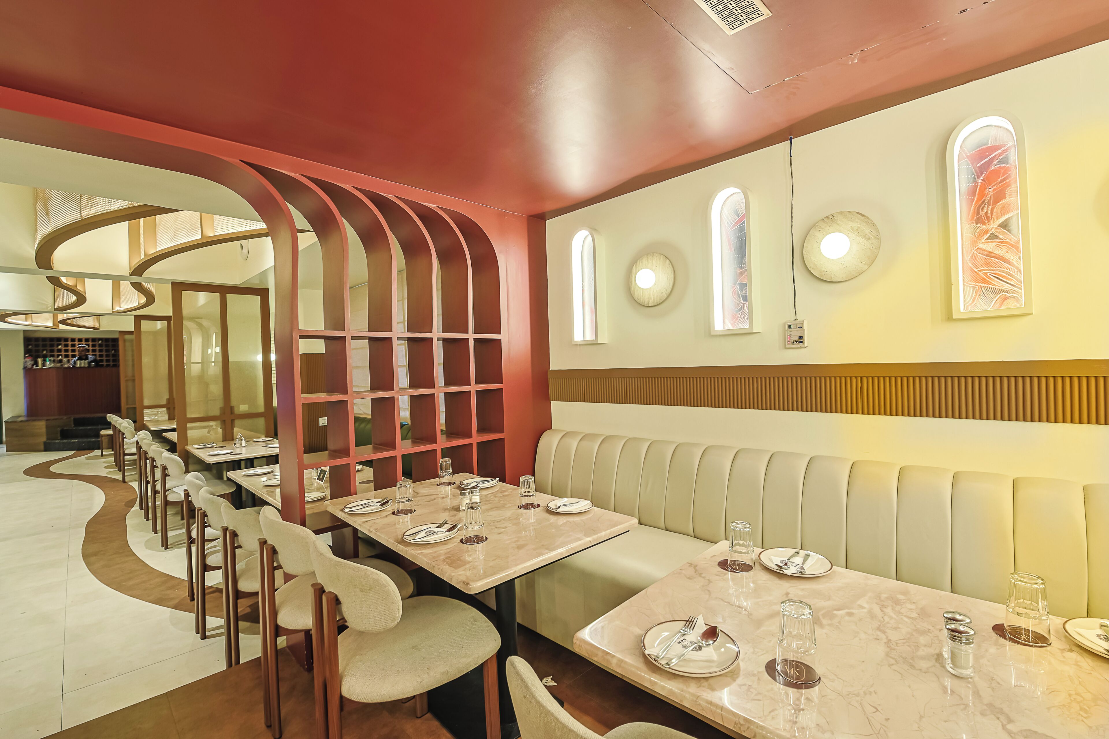 A restaurant interior with a long dining table, cushioned booths, and a modern design.