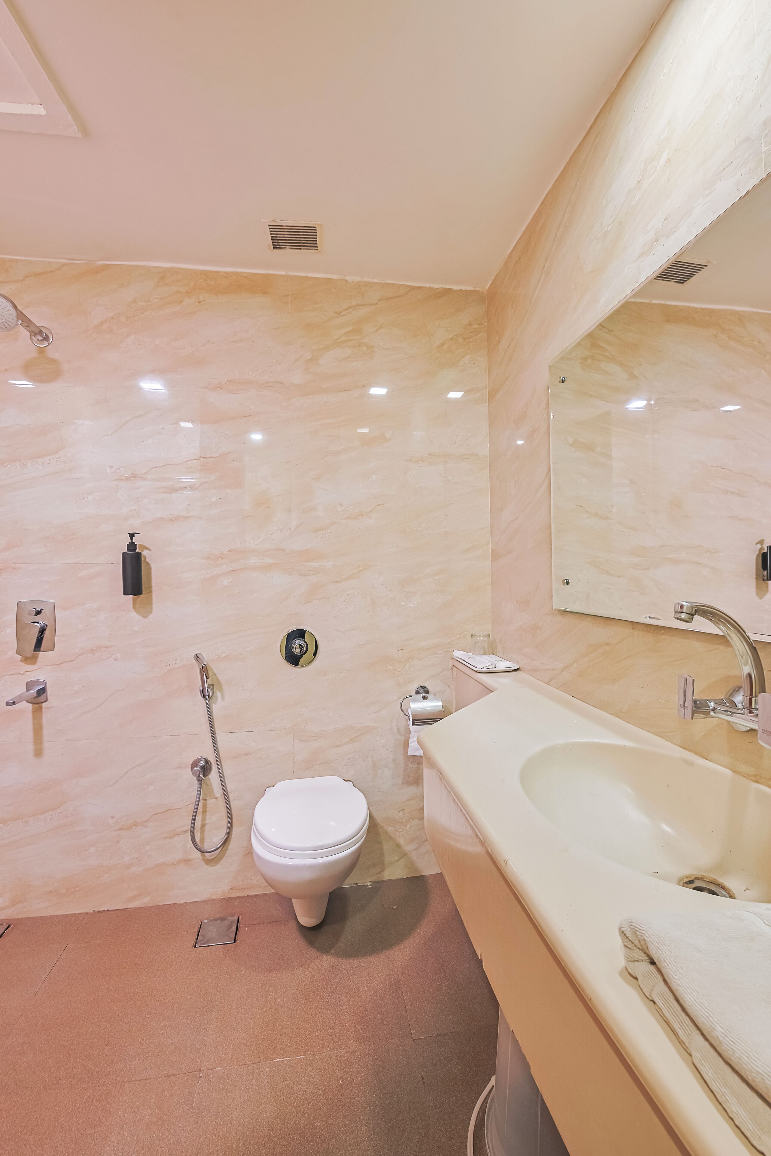 A bathroom with a toilet, bidet, sink, and mirror.